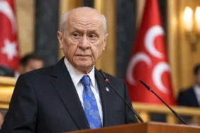 Devlet Bahçeli, Türk bayrağı ve MHP bayrakları önünde kürsüde